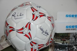 The ball presented by Age UK's Roger Jones, signed by Stiles, Cohen & Wilson